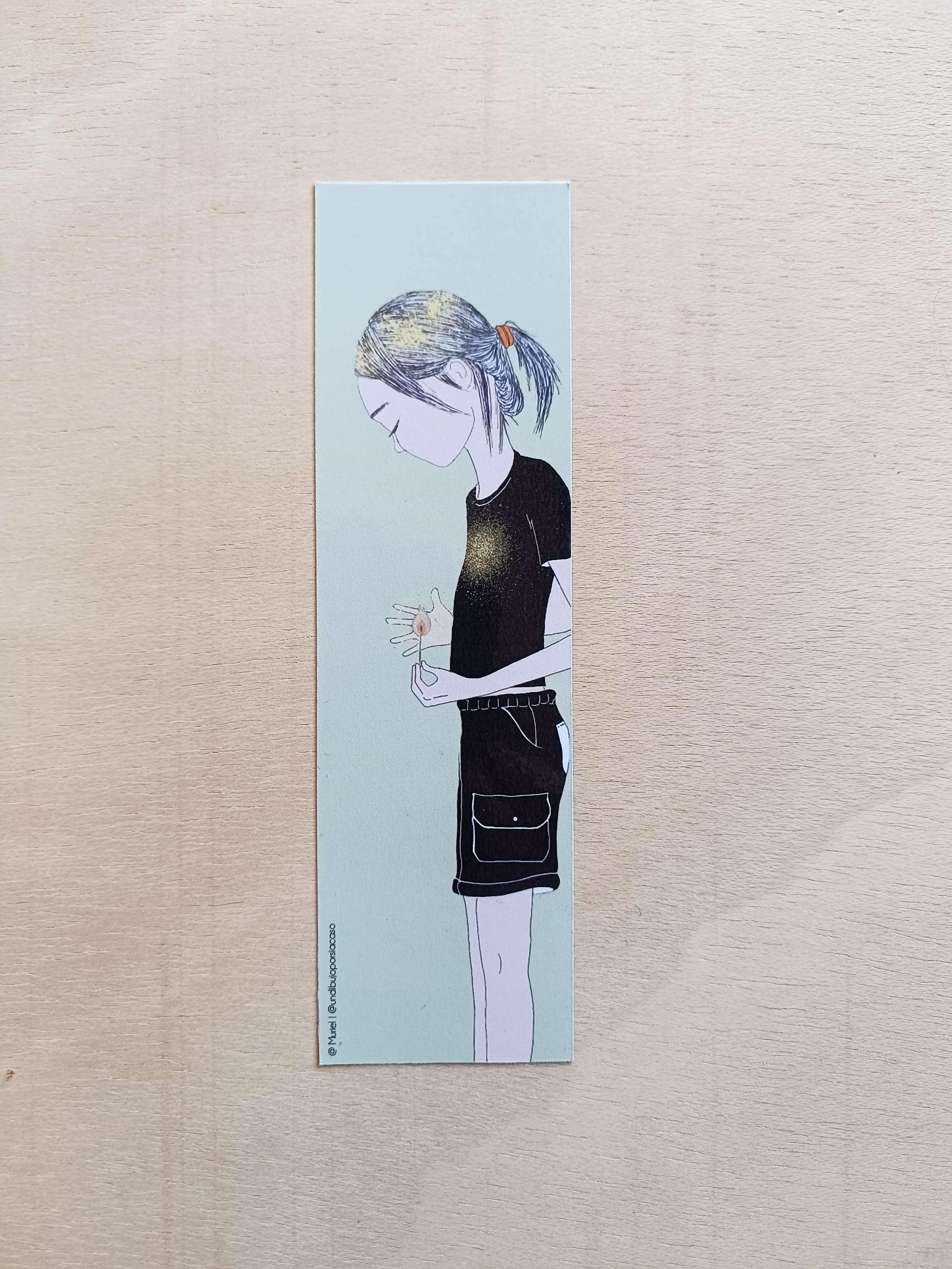 Marcapáginas de libro con ilustración que representa a una persona de perfil con una cerilla encendida en la mano.