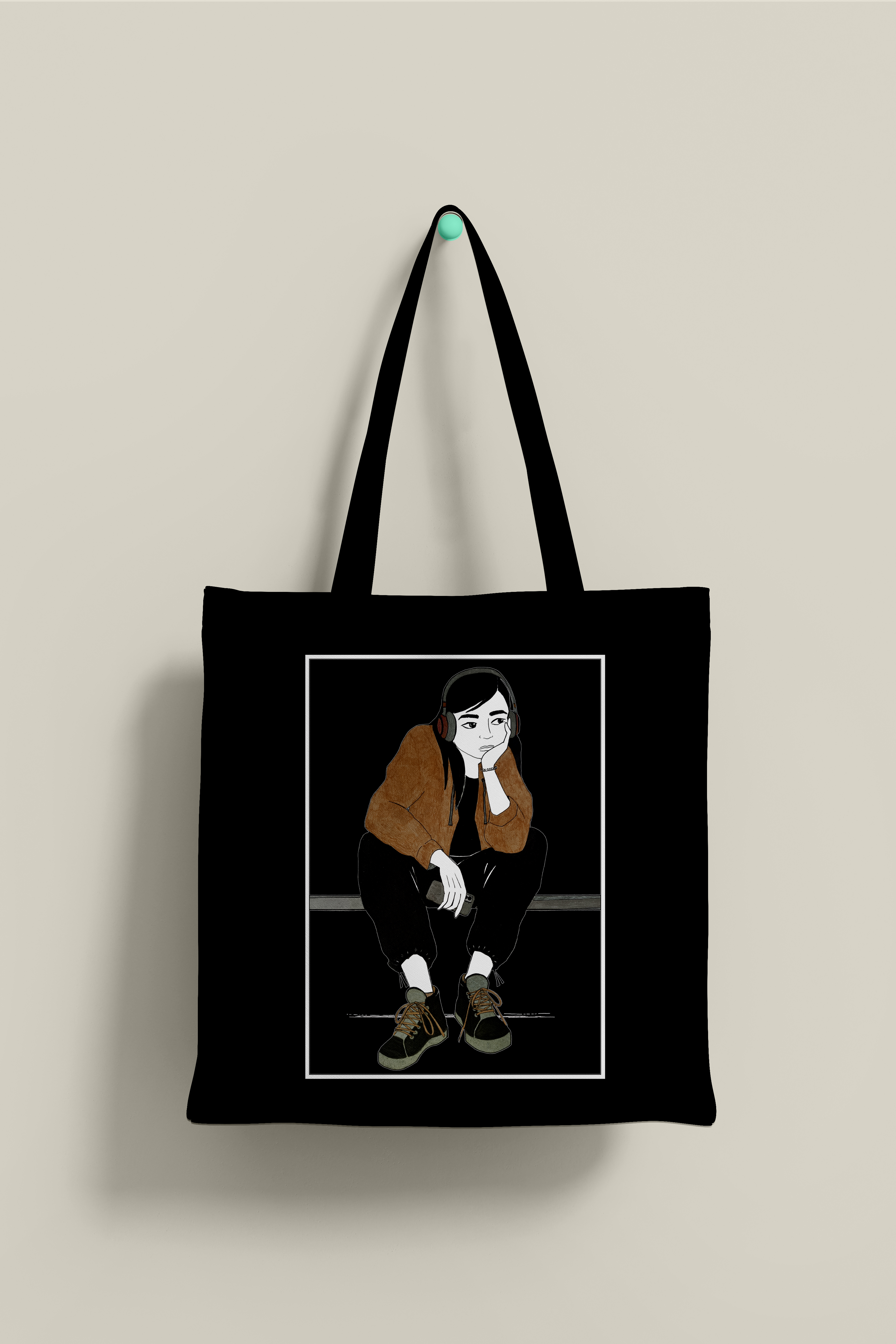 Bolsa de tela de color negro, con ilustración que representa una chica sentada con auriculares puestos y móvil en la mano.
